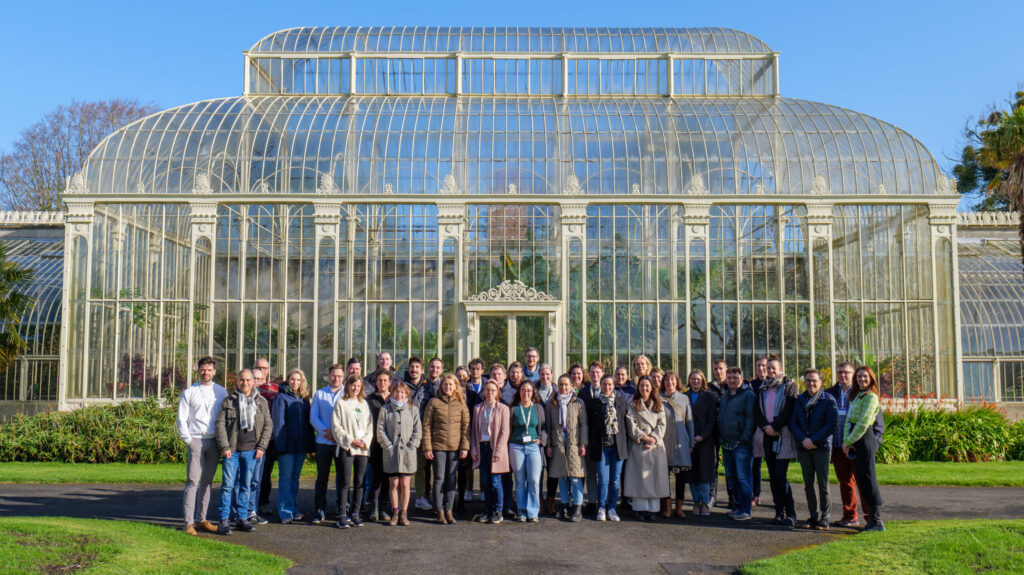 Group of ClimateSmartAdvisors participants standing in front of a large glass greenhouse during the first Communities of Practice wave event, highlighting peer learning and climate-smart advisory collaboration across Europe.